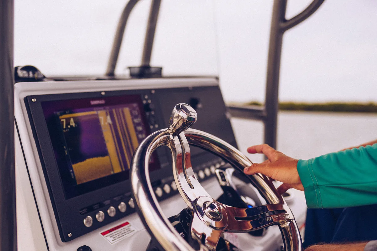 A captain at the helm of a boat